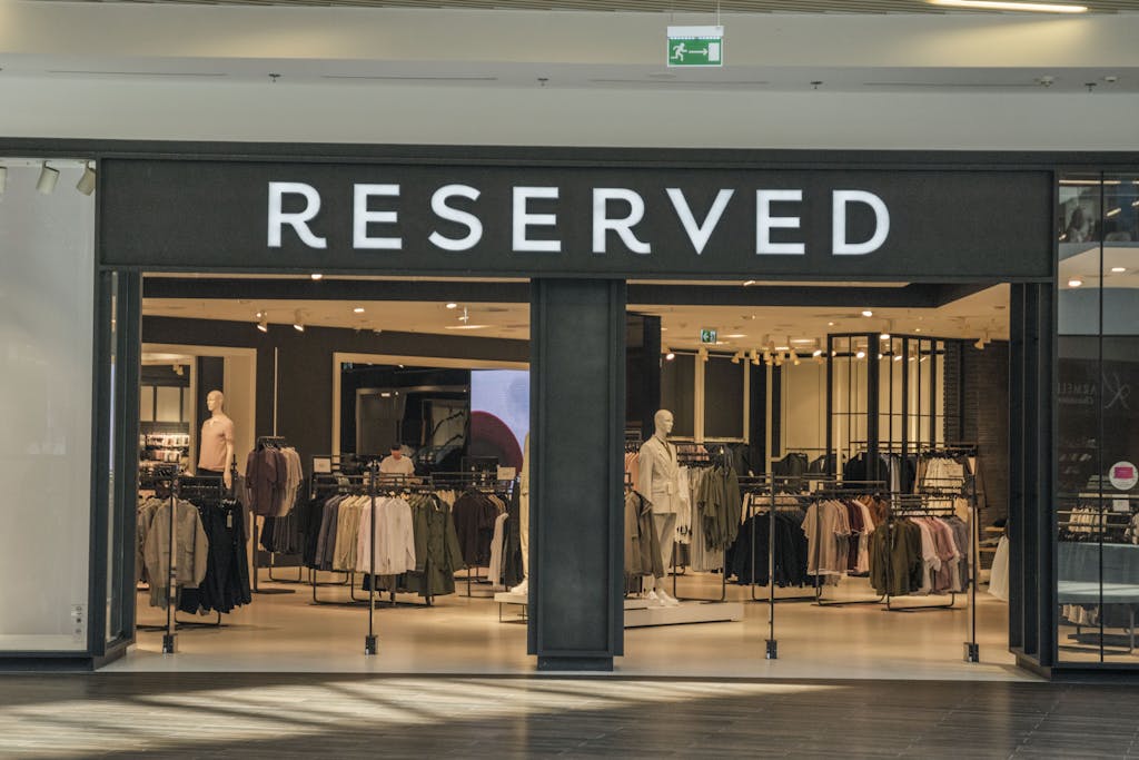 Chic clothing store entrance in a bustling shopping mall, showcasing trendy apparel.